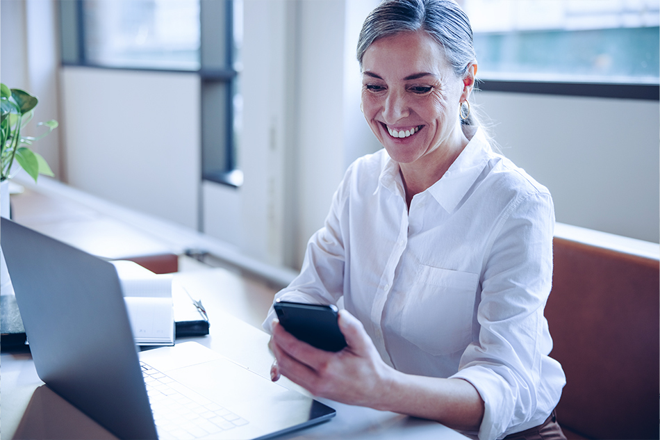 Kvinne foran PC benytter Personportalen og smiler