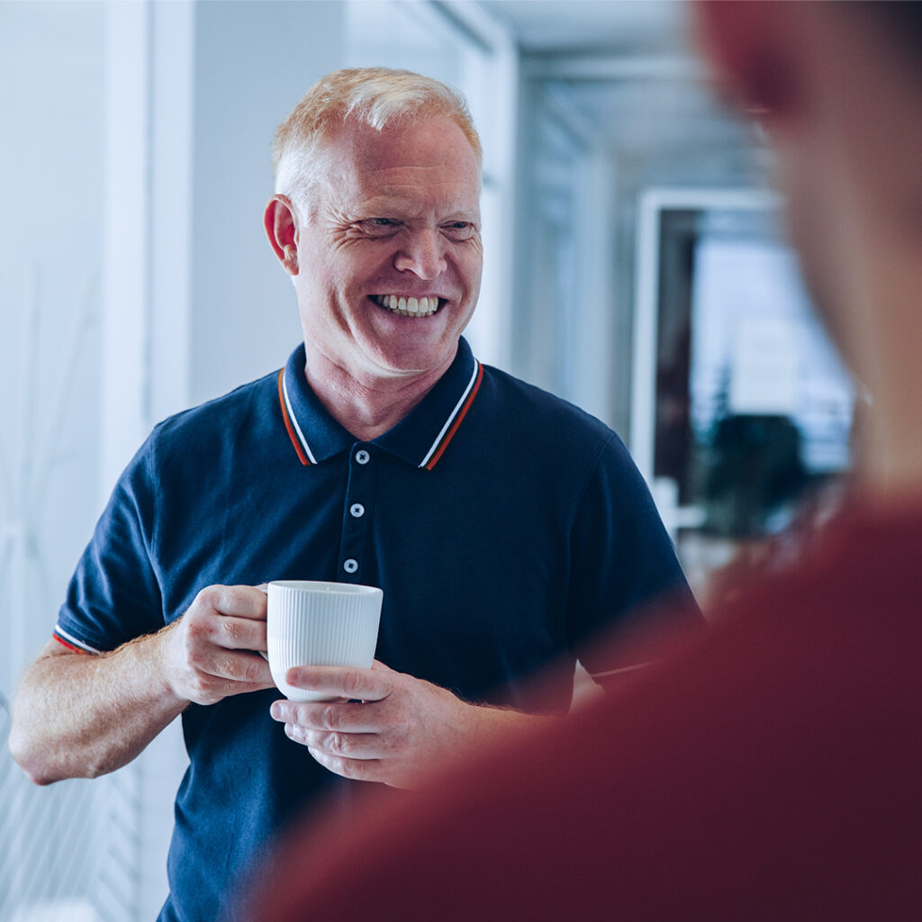 Bilde av smilende mann som holder en kaffekopp